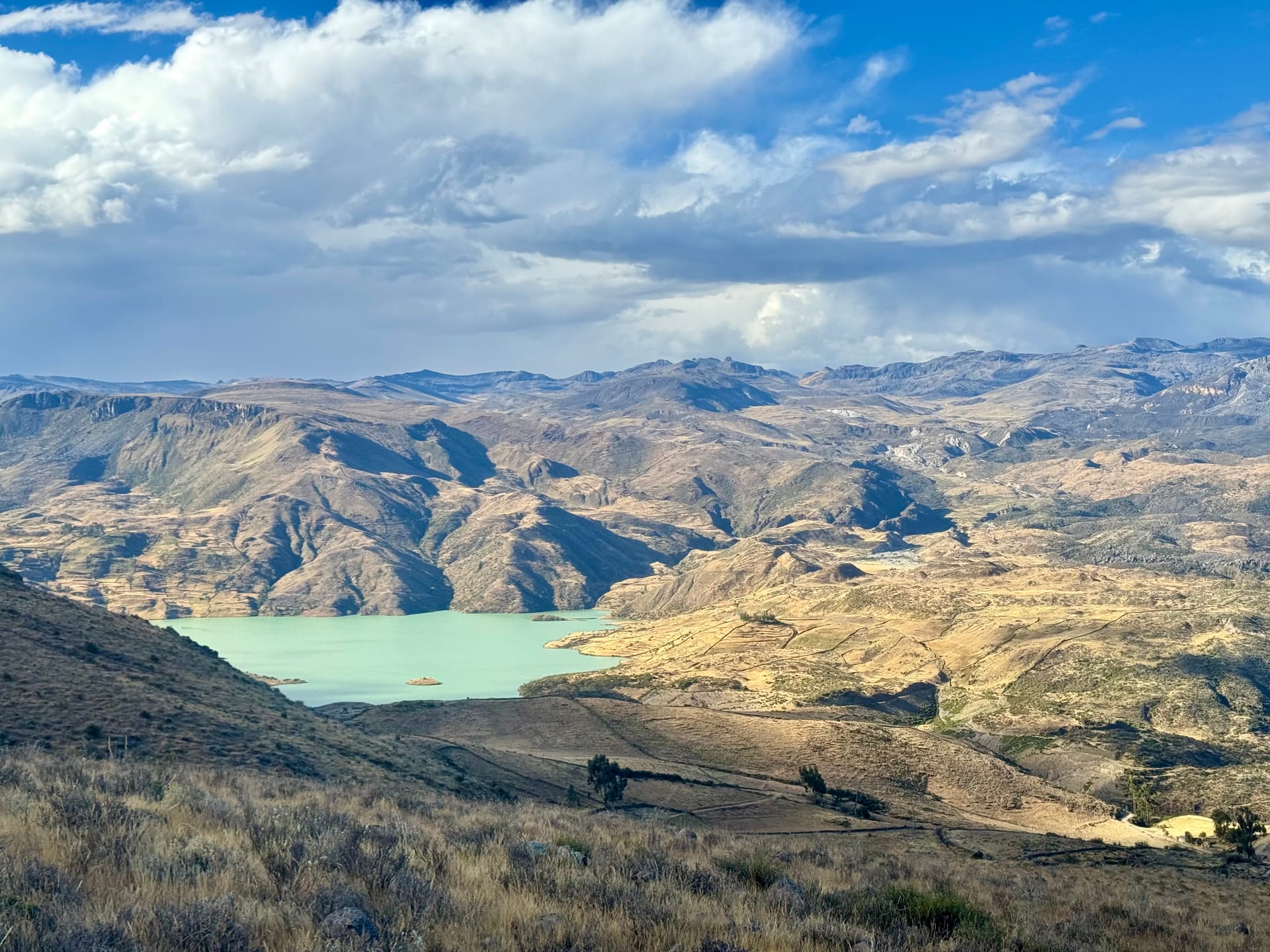 Lagune turquoise entre des collines dorées sur la piste vers Puquio